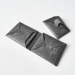 折紙のように折られた一枚革。ブランド初の革小物は木目型押しレザー